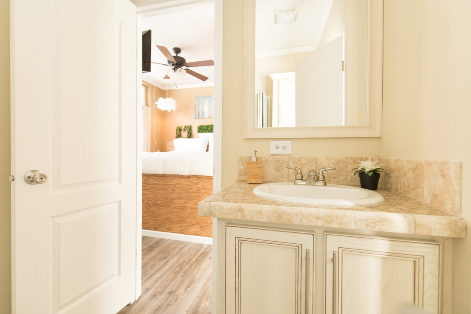 Cream-colored bathroom with cream marble sink and counter under a cream-colored framed mirror