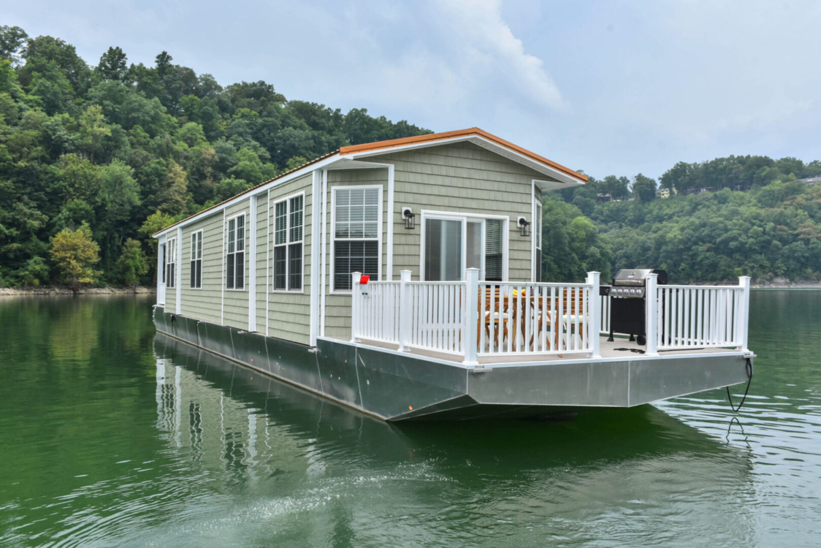 White-fenced deck of the bow area of a green houseboat