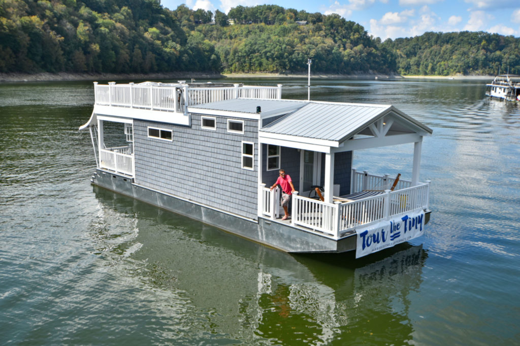 Small blue houseboat in the middle of a body of water